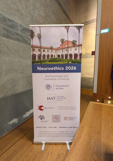 Rollup banner for Neuroethics 2026 conference showing a building with palm trees, event title, subtitle, and logos of participating institutions